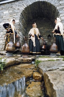 Women in traditional dress getting water from a well in lagich, azerbaijan, 1990s.