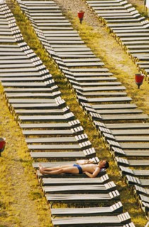 A lone man sunbathing at a resort in sochi in the krasnodar region of russia where the number of vacationers dropped 44% from the previous year due to the sharp increase in prices, july 1992.