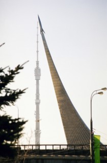 The monument to the explorers of space (space obelisk) at vdnkh with the ostankino television tower in the background, moscow, russia, 2004.