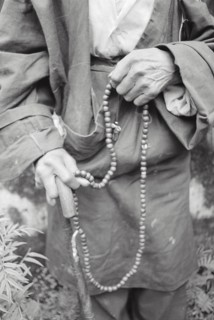 Buddhist man chanting on beads, Darjeeling, West Bengal, India