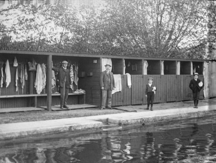 Outdoor swimming pool in the Victorian era with two boys waiting to go for a swim