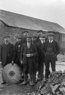 A historical image of a group of men standing together in suits and hats