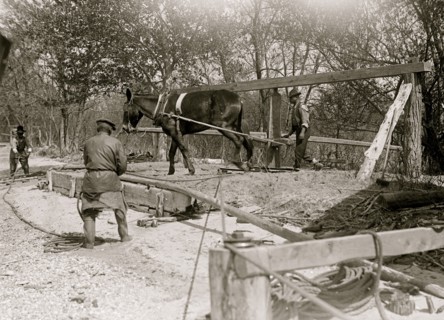 African American drilling a well with a horse on a turnstile