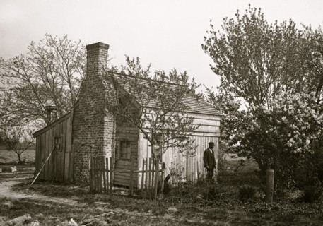 African American man in front of small house
