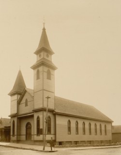 African American man standing on sidewalk in front of church
