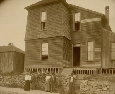 African Americans standing on sidewalk in front of house in Georgia