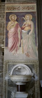 Italy. Florence. Mural painting with saints and stoup. 14th-15th century. Basilica of San Miniato al Monte.