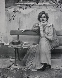 pretty woman with dreamy look sitting on a bench  /  hübsche Frau mit verträumtem Blick sitzt auf einer Bank