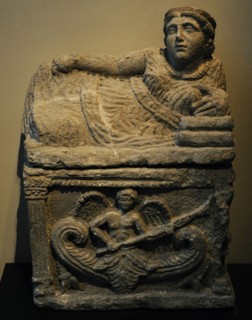 Roman cinerary urn with a reclining female figure at the top