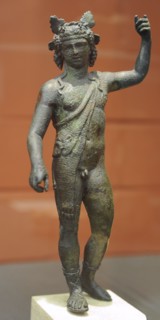 Bronze statuette of God Dionysus with panther skin, sandals and crown of clusters and vine leaves.