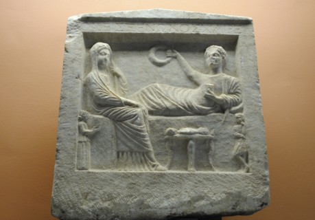 Tombstone. 'Parting scene' in relief.