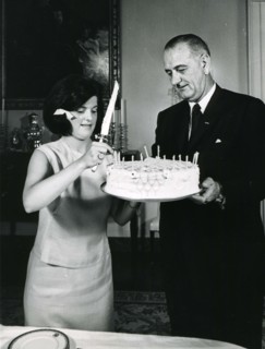 White House, July 2, 1964 -- Luci B. Johnson,accompanied by her father President Lyndon B. Johnson, prepares to cut the cake at her 17th birthday party. Photo: Abbie Rowe
