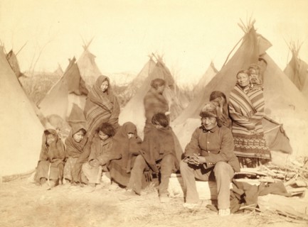 Group of eleven Miniconjou (children and adults) in a tipi camp, probably on or near Pine Ridge Reservation. 1891.