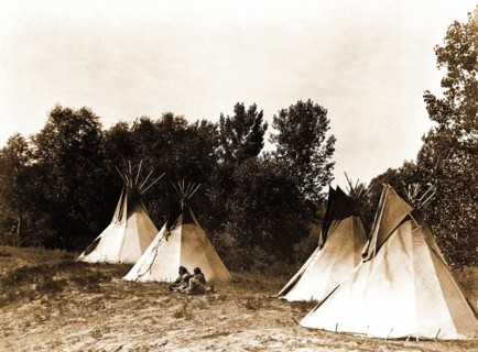 Edward S. Curtis Native American Indians - An Assiniboin camp containing four tepees with Indians seated on ground circa 1908.