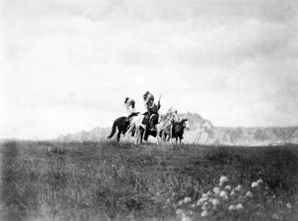 Edward S. Curits Native American Indians - Three Sioux Indians of horseback on plains with rock formation in background circa 1905.