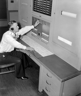 Officer William L. Good is shown at the FBI 'Patrol Board' in the Captain of the Guard's office which maintains direct communication with every watch station and substation throughout the huge FBI Hea...
