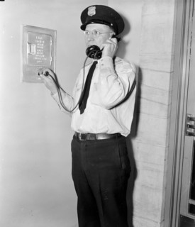 F.B.I. guard reports in. Washington, D.C., Aug 4. Officer Ray D. Buckingham using a plug-in telephone, which every guard carries as part of his regular equipment circa 1937.