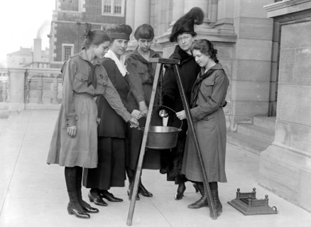 Girl Scouts in 1918 putting money into a kettle (Mrs. Morgan rear right) .