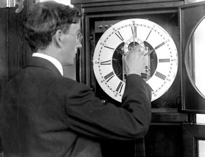 Chester Burleigh Watts turning back the hands of a clock at the Naval Observatory in 1918 (possibly in honor of the first Daylight Savings Time) .