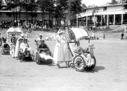 Wounded WW I soldiers at Walter Reed Hospital participate in a 4th of July wheel chair parade circa 1919 .