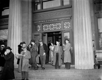 Men standing in front of and exiting the Securities and Exchange Commission circa 1937.