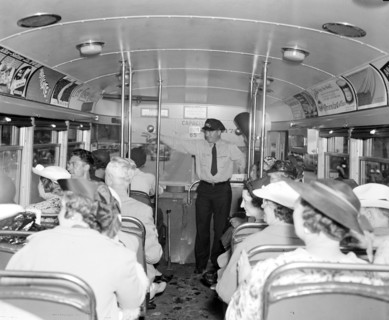 People riding a sightseeing bus circa 1937 .