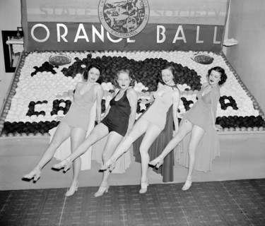 Women posing with California orange week festival ball display circa 1938.