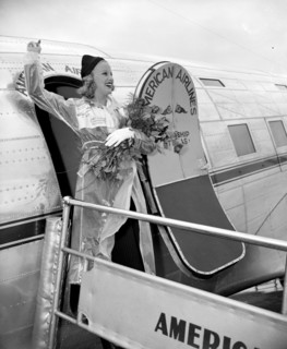 Miss Marion Weldon, Paramount starlet, waves a greeting to the throng as she arrived at Washington Airport today to participate in National Airmail Week circa 1938.
