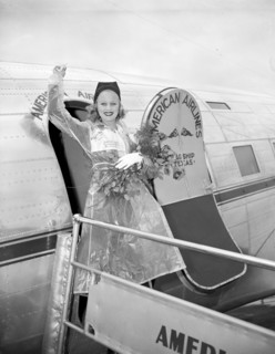 Miss Marion Weldon, Paramount starlet, waves a greeting to the throng as she arrived at Washington Airport today to participate in National Airmail Week circa 1938.