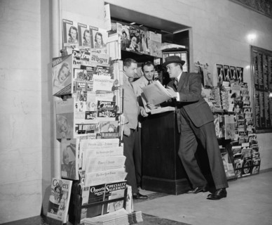 Customer and workers at newstand in the National Press Building circa 1940.
