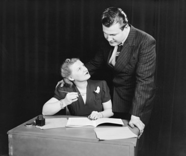 Staged photo of a man and woman (possibly married couple) working on a monthly budget circa 1940 .