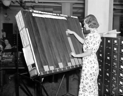 Social Security History - a worker in the Social Security Board Records Office at work at the 'visible control' rack circa 1937 or 1938 .