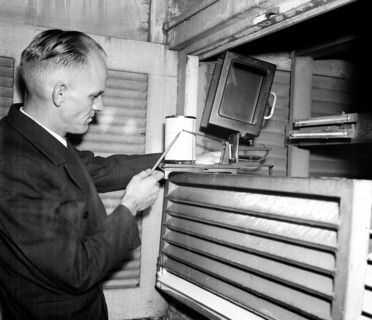 Weather employee at typical weather station with a temperature chart circa 1936.