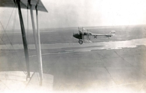 Aerial photograph of Curtiss JN-4 aircraft number C126, taken over open fields and the Bay of Quinte circa 1917.
