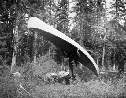 Long Portage (1 2/3 miles into Stillwater Lake)' Man carrying a canoe circa 1909.