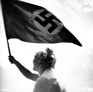 Woman waving Nazi flag circa late 1930s or early 1940s.