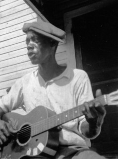 Bill Tatnall, half-length portrait, seated, facing left, playing guitar, Frederica, Georgia circa June 1935.