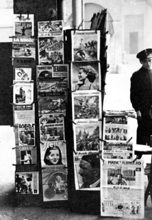 News stand on street corner in Bologna Italy filled with newspapers and magazines for sale circa late 1930s .