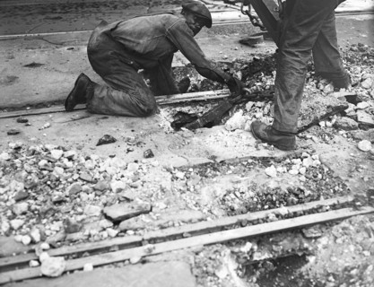 Worker helping with Streetcar track removal circa 1935.