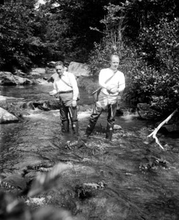 Two men fishing in a river circa 1932.