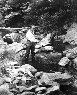 A man fishing in a river circa 1932.