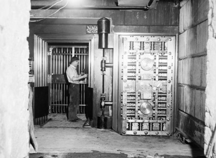 Man working on a large bank vault area circa 1934.