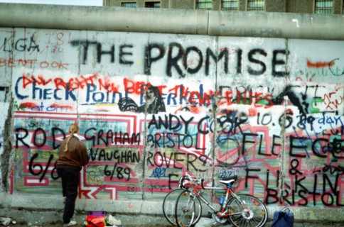 A West German woman attempts to chip off a piece of the Berlin Wall as a souvenir.   A portion of the Wall has already been demolished at Potsdamer Platz..