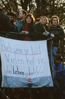 West German citizens display a banner as they maintain a vigil for the demolition of the Berlin Wall near the Brandenburg Gate.  A portion of the Wall has already been demolished at Potsdamer Platz..