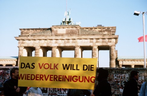 West German citizens display a banner as they maintain a vigil for the demolition of the Berlin Wall at the Brandenburg Gate.  A portion of the Wall has already been demolished at Potsdamer Platz..