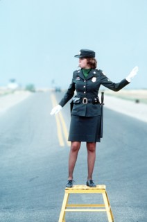 1979 - A U.S. Army military policewoman directs traffic.