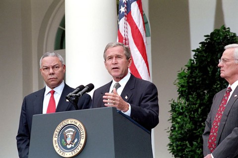 As Secretary of State Colin Powell and Secretary of the Treasury Paul O'Neill look on