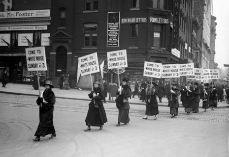 Woman suffragettes marching through the streets