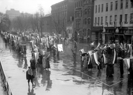 Woman suffragettes marching in the rain