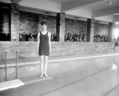 Young woman standing on diving board at a Y.W.C.A. pool